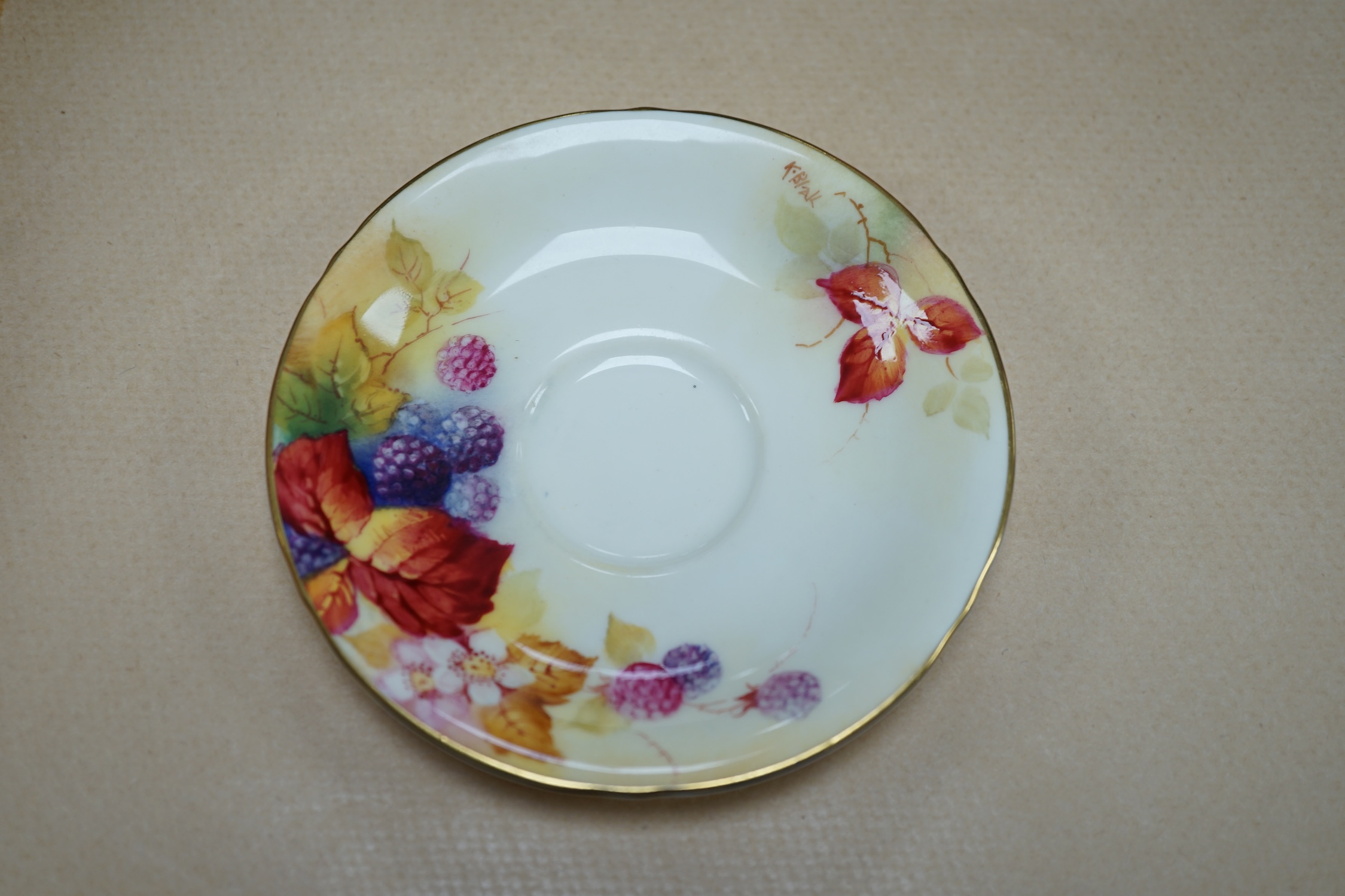 A Royal Worcester fruit painted cup and saucer by Kitty Blake, saucer 11.5cm diameter. Condition - good